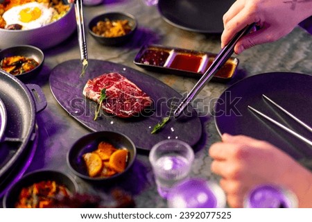 close-up top view delicious appetizing juicy piece of raw meat table with sauces on appetizers in Korean restaurant