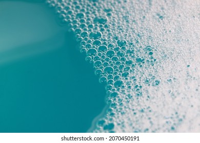 Close-up top view of foamy surface of clean water. Abstract foamy background.
