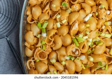 Close-up Top View Green Spring Onions On Snail Pasta With Chicken In Sauce In Glass Plate