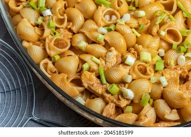 Close-up Top View Green Spring Onions On Snail Pasta With Chicken In Sauce In Glass Plate