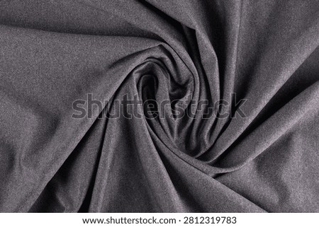 Close-up top view of heather gray dry-fit fabric with a folded, twisted polyamide texture.
