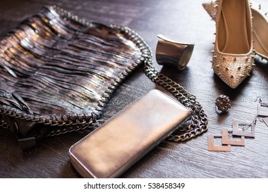 Closeup top view image of fashionable women's bag and shoes aside accessories on a dark wooden background