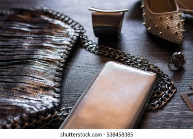 Closeup top view image of fashionable women's bag and shoes aside accessories on a dark wooden background