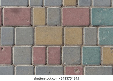 Close-up top view of multi colored tiled stine sidewalk on pedestrian city street. Copy space for your text or decoration. Abstract road background theme.