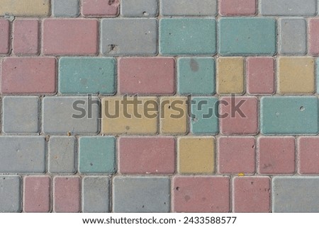 Close-up top view of multi colored tiled stine sidewalk on pedestrian city street. Copy space for your text or decoration. Abstract road background theme.