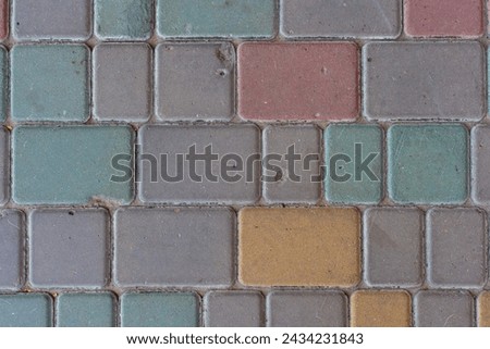 Close-up top view of multi colored tiled stine sidewalk on pedestrian city street. Copy space for your text or decoration. Abstract road background theme.