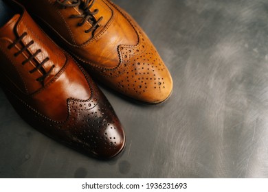 Close-up top view of old light brown leather shoe and repaired shiny shoes after restoration working. Concept of cobbler artisan repairing and restoration work in shoe repair shop. - Powered by Shutterstock