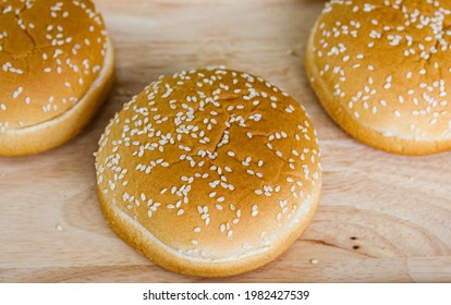 Closeup Top View Shot Of Three Delicious Tasty Yummy Organic Wholegrains With Sesame Seed Soft Plain American Fresh Baked Burger Bun Fast Food Placed On Wooden Cutting Board With Copy Space For Text.