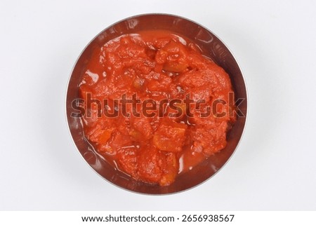 Close-up, top-down studio shot features a metal bowl filled with rich, chunky crushed tomatoes, perfect for cooking delicious meals