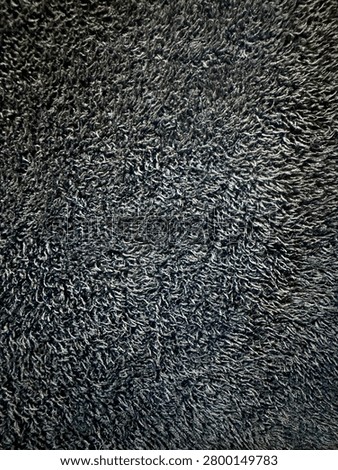 Close-up top-down view of a dark blue plush terry cloth fabric texture with soft fiber loops