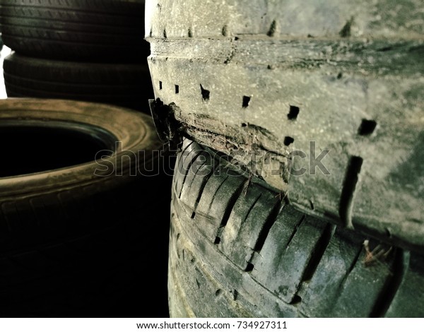 closeup of a lot of torn and damaged tire at a tire\
warehouse 