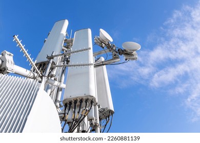 Close-up of a tower with a 5G and 4G cellular network antenna against a blue sky