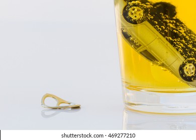 closeup toy car in a glass of beer isolated on white background. Safety concept.
