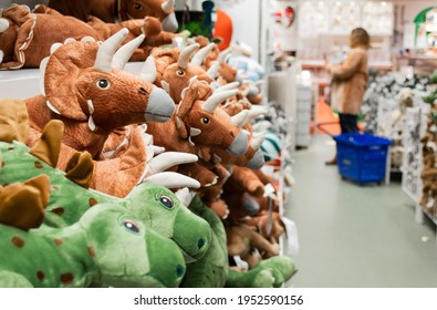 Close-up Of Toy Dinosaurs On Store Shelves. Blurry Shoppers In The Background 