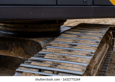 Closeup Of Track Assembly Under Cab Of Backhoe At Construction Site.