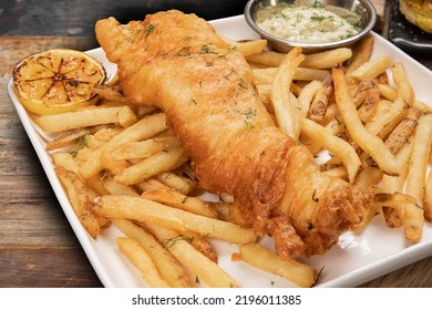 Closeup Of Traditional British Pub Fare, A Crispy Battered Haddock Filet With French Fried Chips And Tartar Sauce