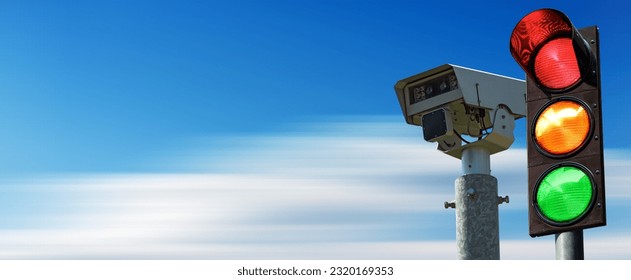 Closeup of a traffic light and a traffic control camera against a clear blue sky in motion with copy space.