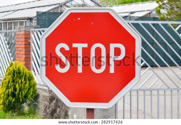 Closeup of a traffic stop sign by the road\
near an intersection