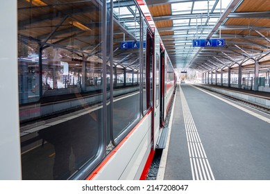 Close-up of train arrived on platform. Reflection on locomotive railroad vehicle reached at station. Mode of transport in alpine region.