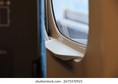 Close-up of a train window with raindrops.