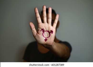 closeup of a transgender symbol painted in the palm of the hand of a young caucasian person