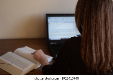 Closeup of a translator working with CAT (Computer-Assisted Translation) tool and dictionary.