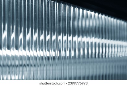 Closeup translucent glass vertical pattern texture background.