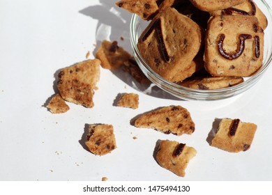 Closeup Of Transparent Glass Plate With Cookies With Raising And Chocolate Numbers, Cookie Crumbs On A White Background In Warm Colors.