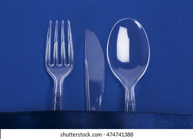 Close-up Of Transparent Plastic Cutlery. Knife, Fork, Spoon On Blue Paper Background. Premium Fast Food Concept. Premium Takeaway Food 