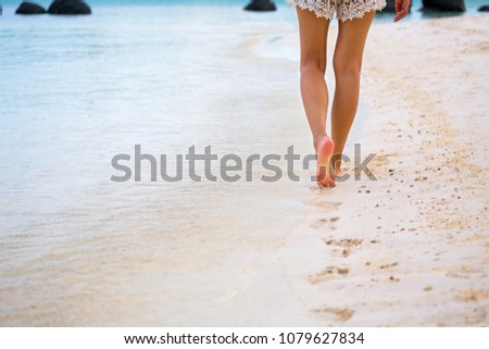 Closeup travel woman foot of walking on beach with sea wave in summer, holidays background, vacation concept