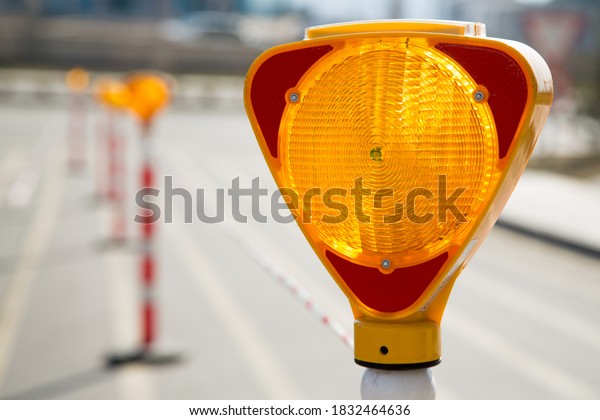 Close-up of a\
triangle-shaped flasher traffic warning light, which is positioned\
to ensure traffic\
safety.