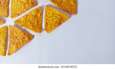 Close-up of Triangular Yellow Nacho Chips on White Background Corner