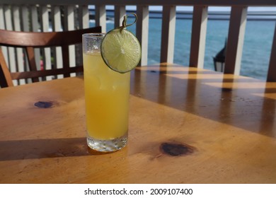 A Closeup Of A Tropical Mai Tai Cocktail On A Wooden Table With An Ocean View In Kona, Hawaii