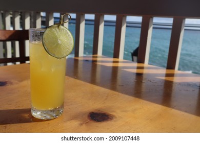 A Closeup Of A Tropical Mai Tai Cocktail On A Wooden Table With An Ocean View In Kona, Hawaii