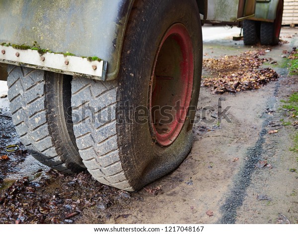 Closeup of truck flat tire on a day of winter rain road\
safety 