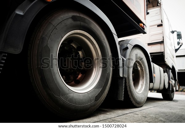 Closeup truck wheels and truck tires of semi\
truck parking at\
warehouse