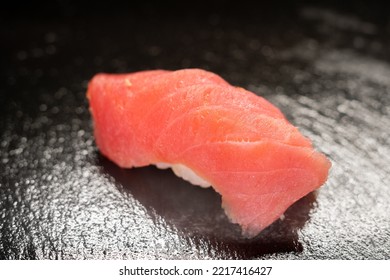 Closeup Of A Tuna Sushi. Japanese Nigiri Sushi With Raw Tuna Fillet. Maguro Sashimi With Rice, Isolation On Black Stone Background. Japanese Cuisine. Pan Asian Menu Dish