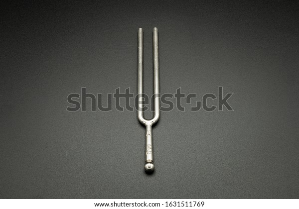 Closeup of\
a tuning fork 440 Hz on a black\
background