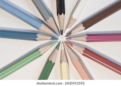 Close-up of twelve colour pencils radially pointing towards each other with their tips - Powered by Shutterstock