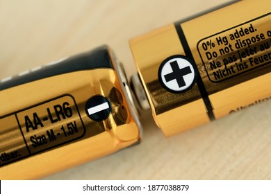 Close-up of two AA size batteries with plus and minus signs - Concept of energy and positive and negative poles