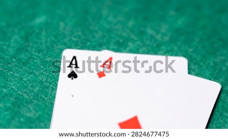 Close-up of two aces. One card shows black spades. The other displays red diamonds. They rest on textured green felt. Ideal for gambling or poker themes. Represents luck in card games