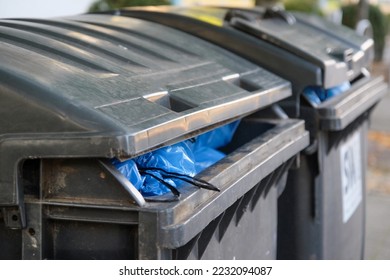 Close-up of two bins filled to the brim with blue bin bags - selective focus - Shutterstock ID 2232094087
