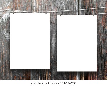 Close-up of two blank frames hanged by pegs against dark wooden background - Shutterstock ID 441476203