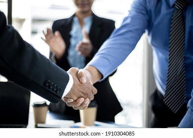 Close-up two business men holding hands, Two businessmen are agreeing on business together and shaking hands after a successful negotiation. Handshaking is a Western greeting or congratulation.  - Shutterstock ID 1910304085