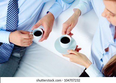 Close-up Of Two Business Partners Holding Cups Of Coffee