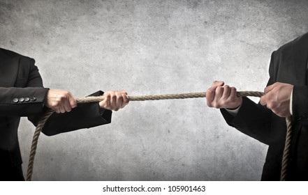 Closeup of two businessmen playing tug of war - Powered by Shutterstock