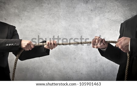Closeup of two businessmen playing tug of war