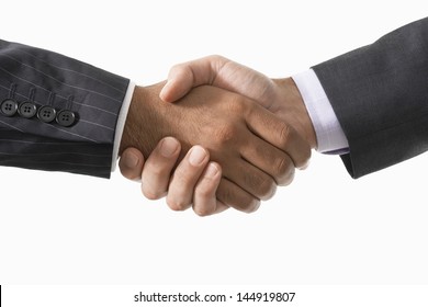 Closeup Of Two Businessmen Shaking Hands Against White Background