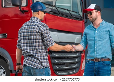 Closeup of Two Caucasian Truck Drivers Swapping the Keys in Front of Red Lorry Cabin Changing Their Shifts For Safe and Secure Delivery of Heavy Duty Cargo. - Shutterstock ID 2187706773