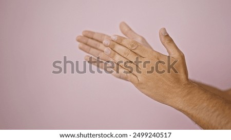 Close-up of two clapping hands against a soft pink background, capturing a sense of celebration or approval.